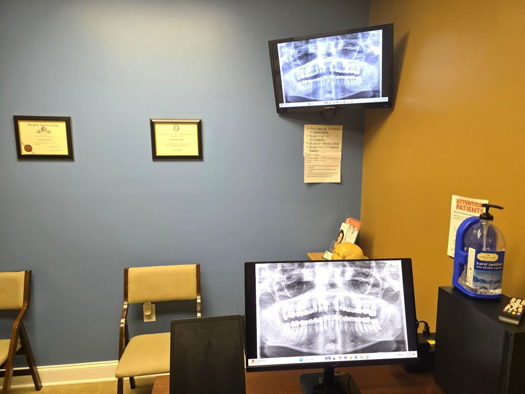 Close-up of a digital diagnostic station showing a panoramic dental X-ray on multiple screens