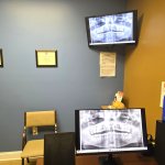 Close-up of a digital diagnostic station showing a panoramic dental X-ray on multiple screens