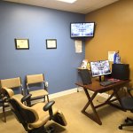 Consultation office with two patient chairs facing a desk with a computer monitor displaying dental X-rays